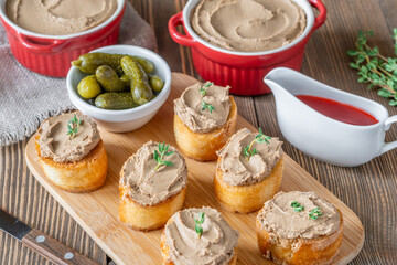 Turkey liver pate on toast with cornichons and cranberry sauce beside