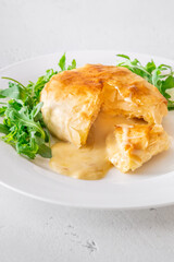 Melted Camembert en Croûte with rosemary garnish and vibrant cranberry sauce accompaniment