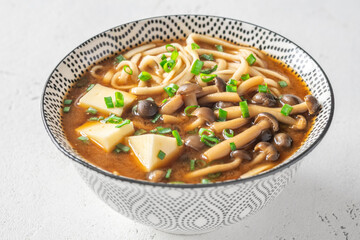 Japanese udon soup with Shimeji mushrooms, tofu, and rich dark umami broth