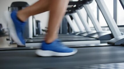 Close up of an athlete's legs in blue sneakers running on a treadmill in the gym. Composite image showing the sequence of motion during a cardio fitness workout - Powered by Adobe