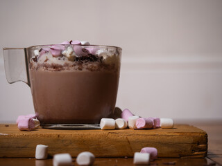 Sprinkling toppings on hot chocolate with marshmallows