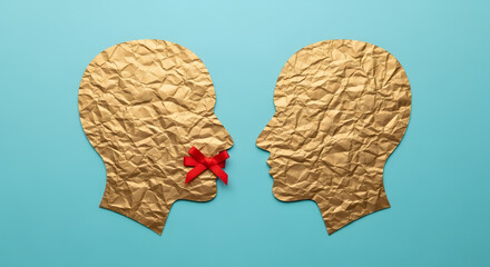 Two silhouette faces look at each other, one has a red cross over his mouth, censorship free speech