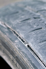 Obraz premium Close-up of worn car tire with visible tread damage