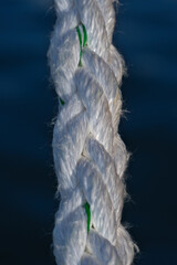 White Nautical Rope Hanging Against Deep Blue Sea, Close-Up