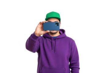 Young man wearing a vibrant purple hoodie and green baseball cap holding a smartphone to capture a photo isolated on transparent background