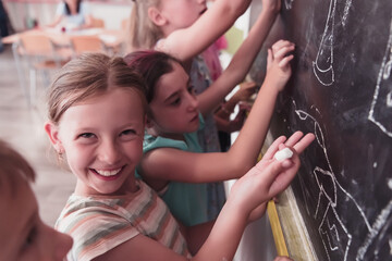 Children write and draw on the blackboard in elementary school while learning the basics of education