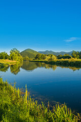 Beautiful river Gacka flowing between the green meadow fields in Lika region, Croatia 