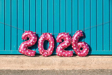 balloons forming the number 2026 by a blue wall