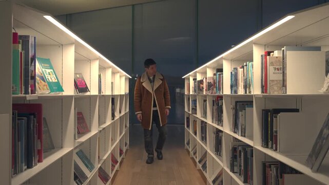 A man looking for books in Oodi Library, the modern central library in Helsinki, Finland