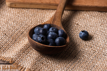Rustic wooden ladle with blueberries.