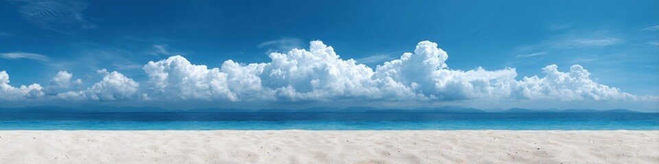 Fototapeta premium Serene beach with blue sky and white clouds on a sunny day