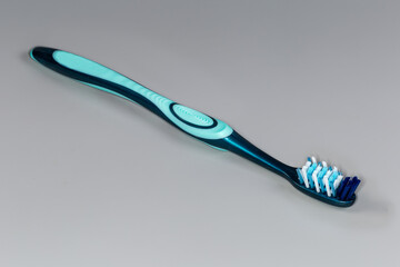 Modern traditional toothbrush with hard multidirectional bristles on gray background