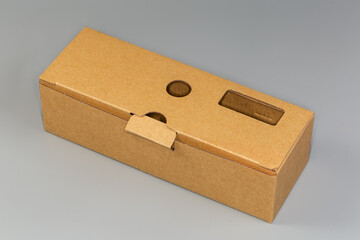 Closed rectangular long cardboard packing box on a gray background
