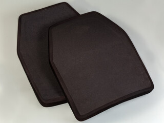 Two polyethylene armor plates for bulletproof vest on gray background