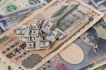 Miniature Dollar Stacks on Japanese Yen Background