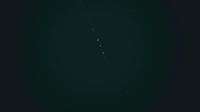 A fishing line and float gently drifting on dark water, minimal and serene