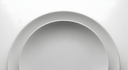 Abstract composition featuring two overlapping smooth white ceramic plates creating minimalist curved shapes and soft shadows