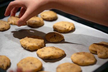 Kinderhände beim Formen von Plätzchen auf Backpapier
Children's hands shaping cookies on baking paper