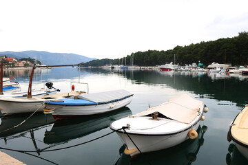 Fototapeta premium Fishing boats and traditional architecture in Stari Grad, small town on island Hvar, Croatia. Rainy wintery day.