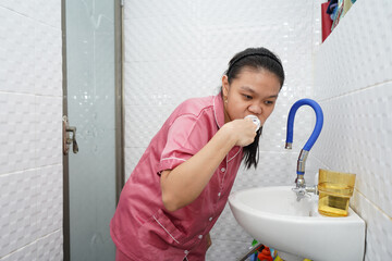 Woman Brushing Teeth Over Bathroom Sink