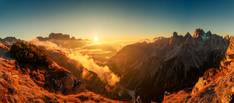 Majestic golden sunrise over mountain ridge and foggy in Cadini di Misurina, Dolomites, Italy