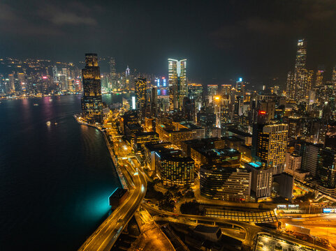 Aerial view of the dazzling city lights reflecting off the water, with iconic skyscrapers piercing the night sky, Hong Kong, Hong Kong Island, Hong Kong.