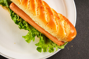 Hot dog fresh bun, sausage, green lettuce leaf homemade sandwich tasty snack fresh delicious gourmet food background on the table rustic food top view copy space