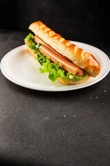 Hot dog fresh bun, sausage, green lettuce leaf homemade sandwich tasty snack fresh delicious gourmet food background on the table rustic food top view copy space