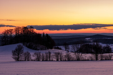 Winter Sunset over Snowy Hills and Trees in the Rh&ouml;n, Germany