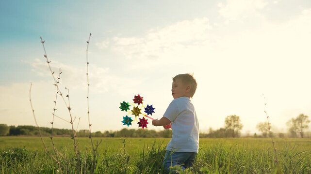 Child walking in field. Boy running on grass in a park. A child running on the grass lifestyle in summer. A kid strolling through a meadow.