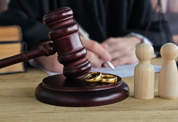 Court session with gavel, rings, and wooden figures during divorce proceedings in a legal office