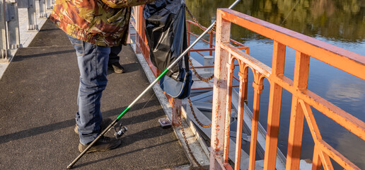 Man is cleaning a bridge with a green pole
