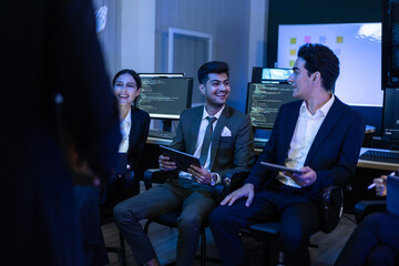 Team of diverse financial analysts and IT experts actively discussing an innovative business strategy at command center. Woman raises her hand to contribute a key idea regarding global market trends