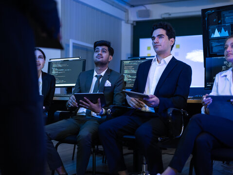 Diverse team of cybersecurity experts, business professionals, and IT specialists intently monitors data on a screen in control room. Teamwork, technology, and corporate security strategy - Powered by Adobe