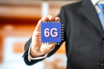 Businessman holding a new 6G microchip. Internet of Things. An innovative communication standard. Ultra fast connectivity and network evolution. Telecom, IoT infrastructure development