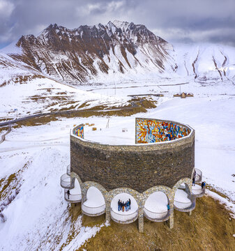 Aerial view of the Chronicles of Georgia monument stands majestically against a backdrop of snow-dusted mountains, Ganisi, Mtskheta-Mtianeti, Georgia.