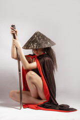 A young lady with a katana in her hand on a white background
