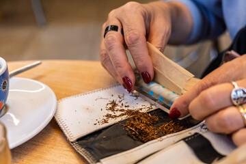Senior Person Preparing a Handmade Cigarette with Rolling Tobacco