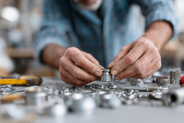A man is holding a small metal object in his hands