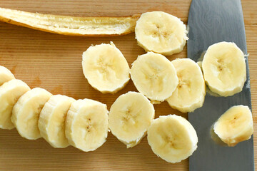 Sliced banana. Ripped banana on chopping board.