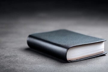 Black book placed on gray surface in simple setting