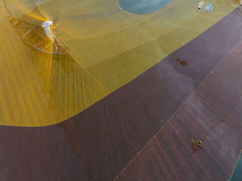 Aerial view of contrasting hues paint an abstract landscape, where amber fields meet earthy browns, divided by subtle gradients and textures, Hoi An, Quang Nam, Vietnam.