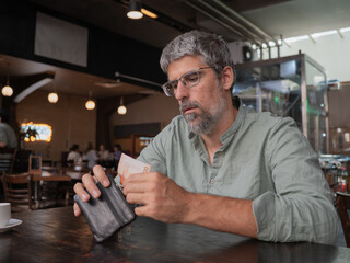Man paying cash from wallet in cafe