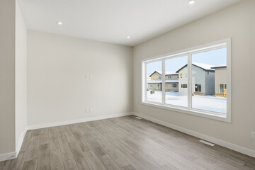 Large empty room with a window and a white wall