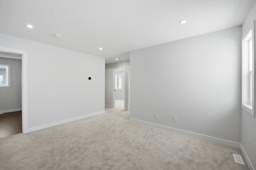 Large, empty room with a white wall and a white carpet