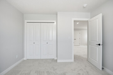 White bedroom with a white door and white closets