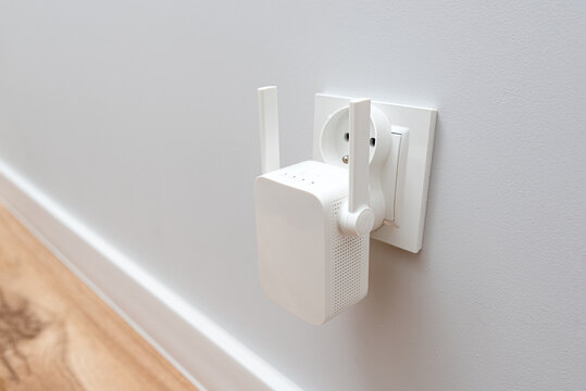 Wireless Wi-Fi repeater on white wall indoors
