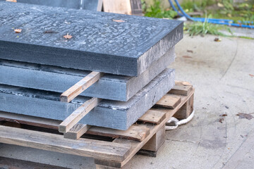 three sawn black granite slabs