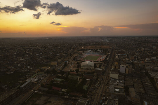 Aerial view of the Sani Abacha Stadium, bathed in the warm glow of the setting sun, stands amidst the sprawling cityscape, Kano, Kano, Nigeria.