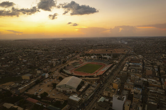 Aerial view of the vibrant Sani Abacha Stadium amidst a sprawling cityscape bathed in the warm hues of sunset, Kano, Kano, Nigeria.